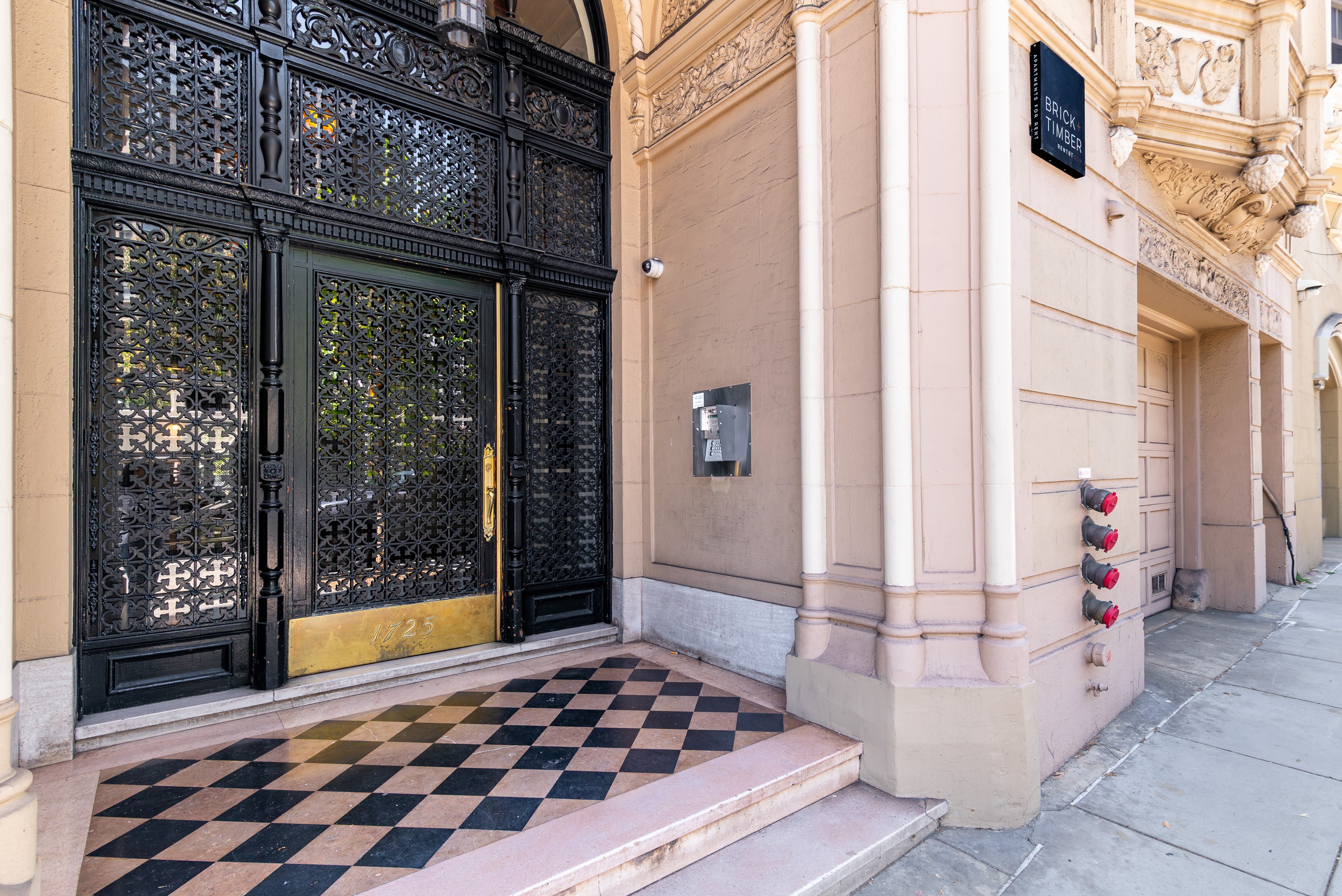 A black and white checkered floor leads to a set of double doors.